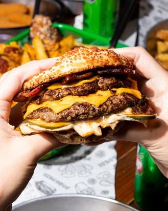 Hamburguesa doble sostenida con las dos manos